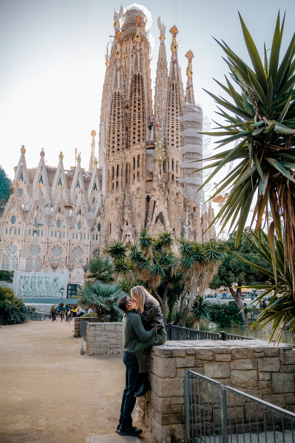 Golden light casting romantic shadows as the couple hugs at Sagrada Família.
