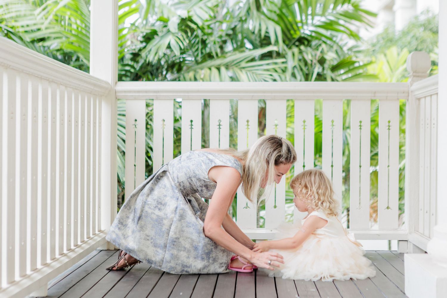 A Relaxed Family Photoshoot in a Singapore Condo. Russian caucasian mom with a blond curly hchild in light wooden balcony with green foliage