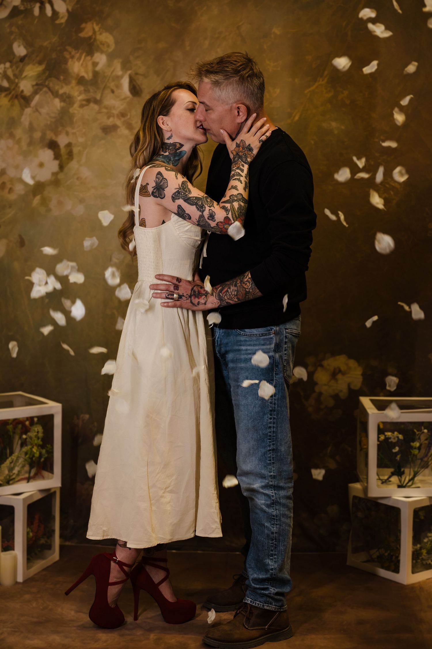 An editorial lifestyle portrait of a couple sharing a quiet moment in a textured, indoor setting, showcasing natural tones and a refined aes