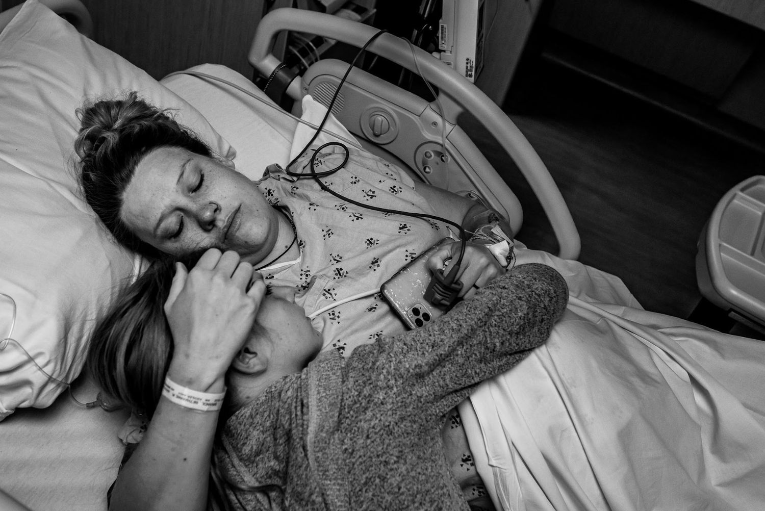 Mom and daughter resting in hospital bed after a home birth transfer