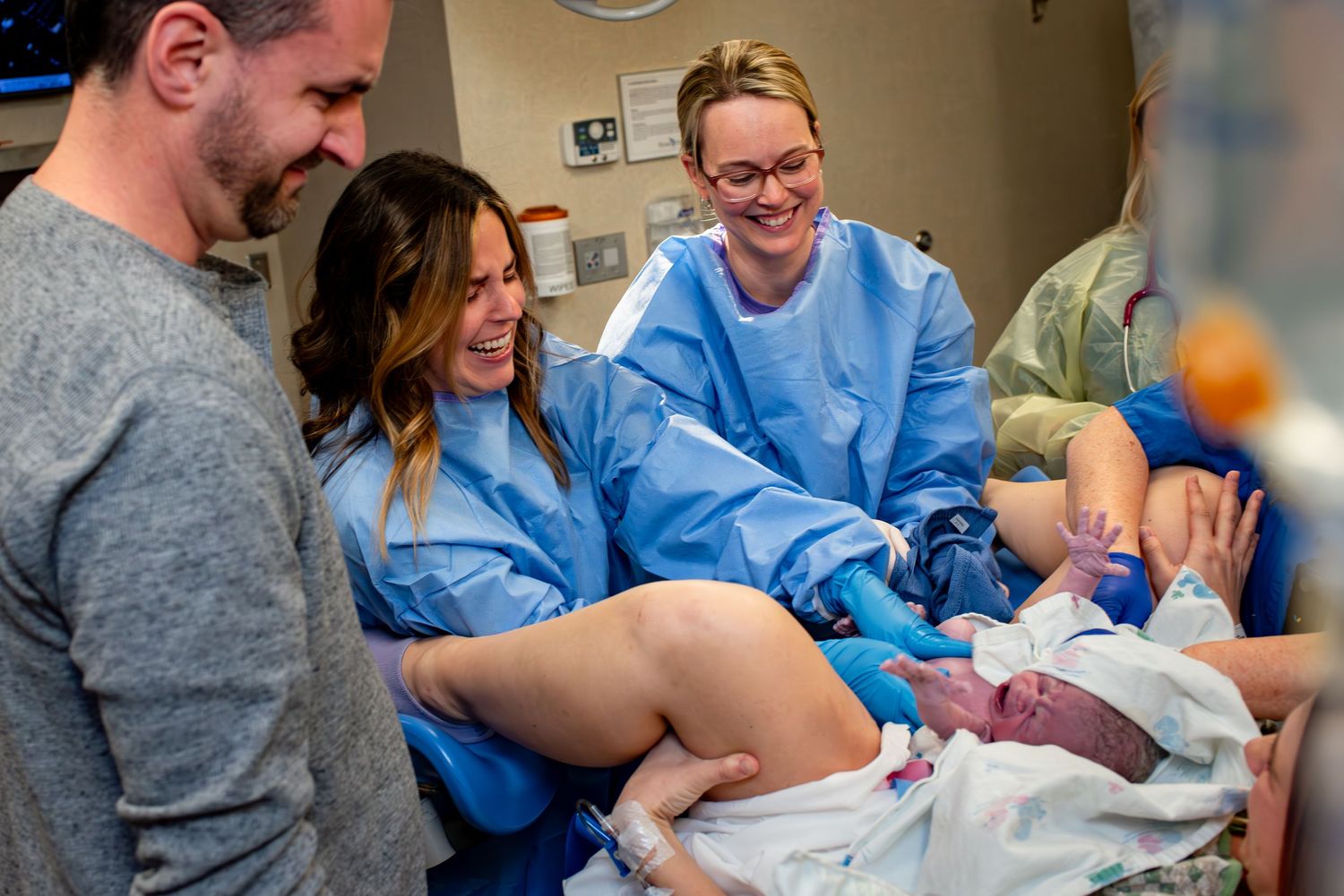 Bio mom delivers her baby and places her on the chest of the surrogate mom.