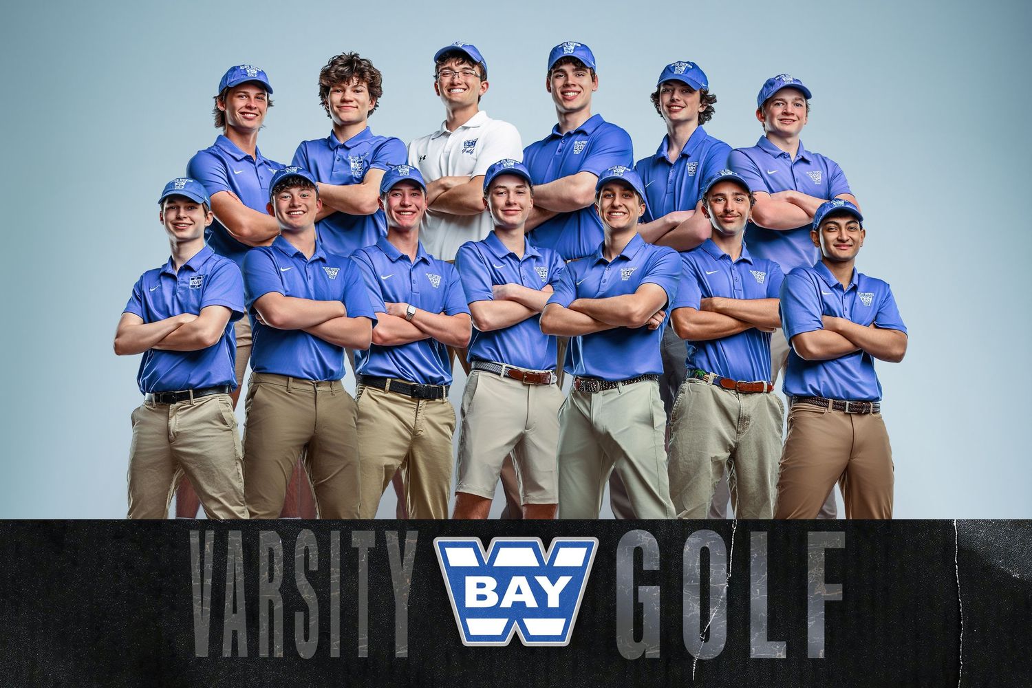 Bay Varsity Golf team photo featuring players in blue polo shirts and khaki pants posing together for a professional team portrait.