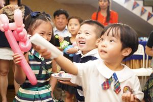 Group of excited children watching a balloon art performance.