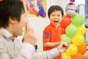 Children playing with colorful balloons at a celebration.