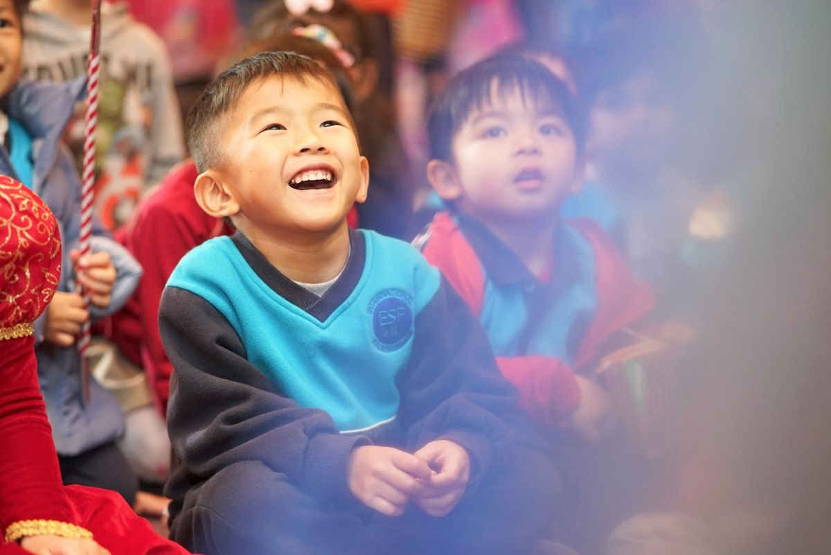 Children watch with delight during festive indoor entertainment.
