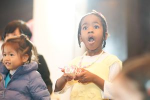 Children react with excitement during indoor performance.