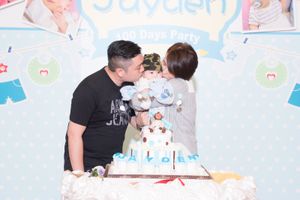 A birthday celebration with a tiered blue and white cake decorated with stuffed animals.