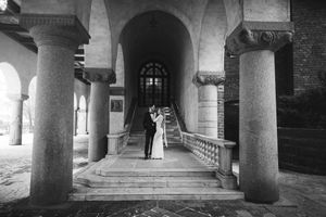 Black and white architectural photograph showing a series of arched stone columns creating a covered walkway or colonnade.
