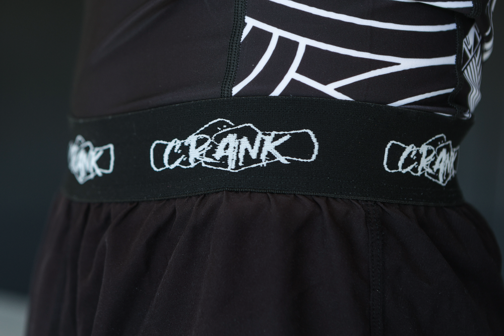Close-up of black CRANK branded elastic waistband on athletic shorts.