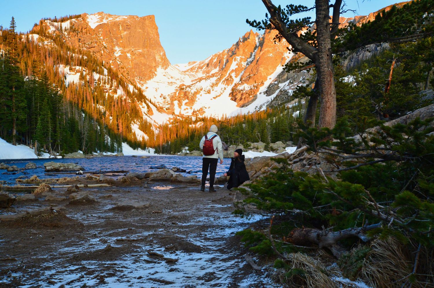 She is proposing to her girlfriend at Dream Lake with Hallets Peak glowing orange in the background.