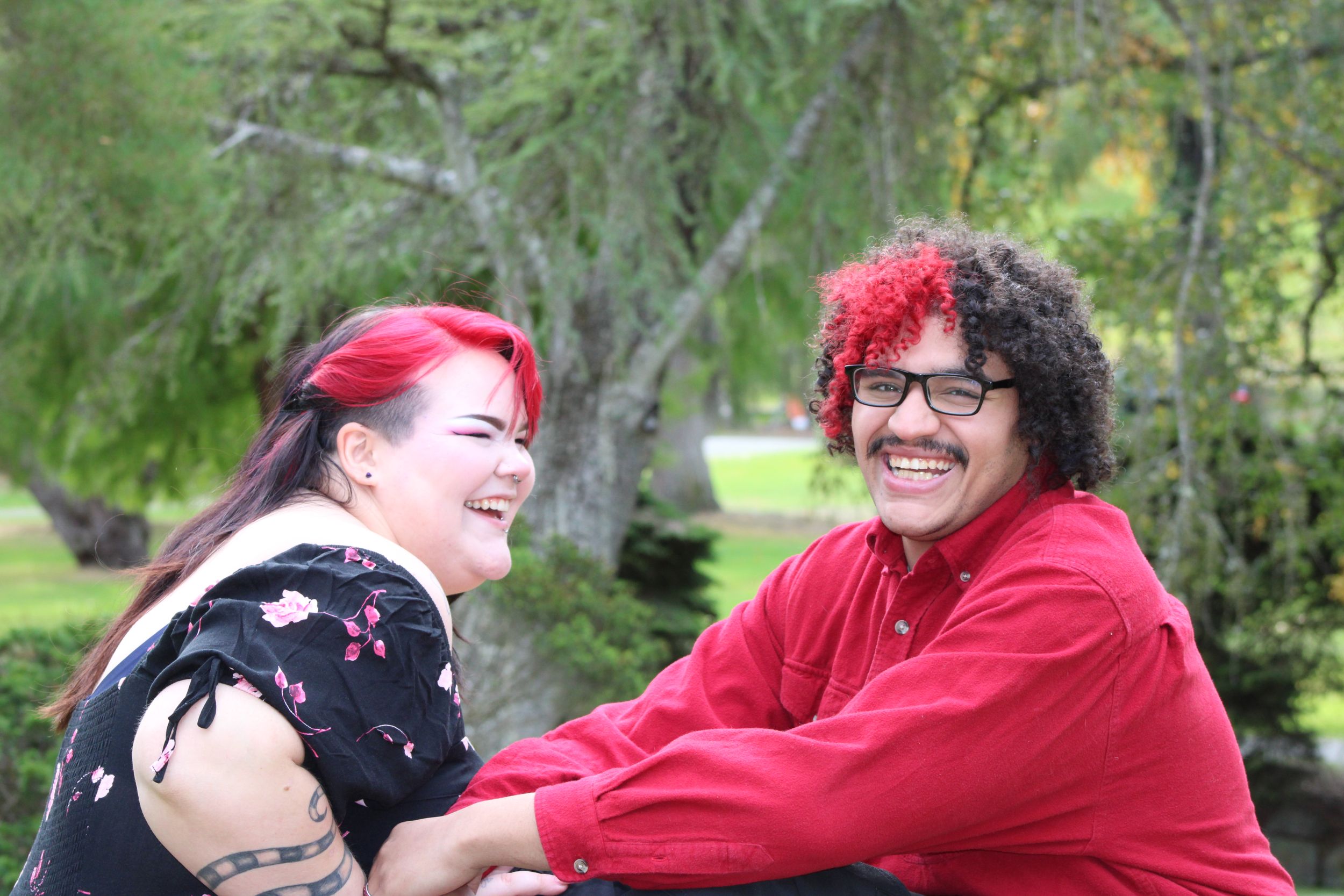 Couple laughing together during an outdoor engagement session, capturing genuine joy and connection