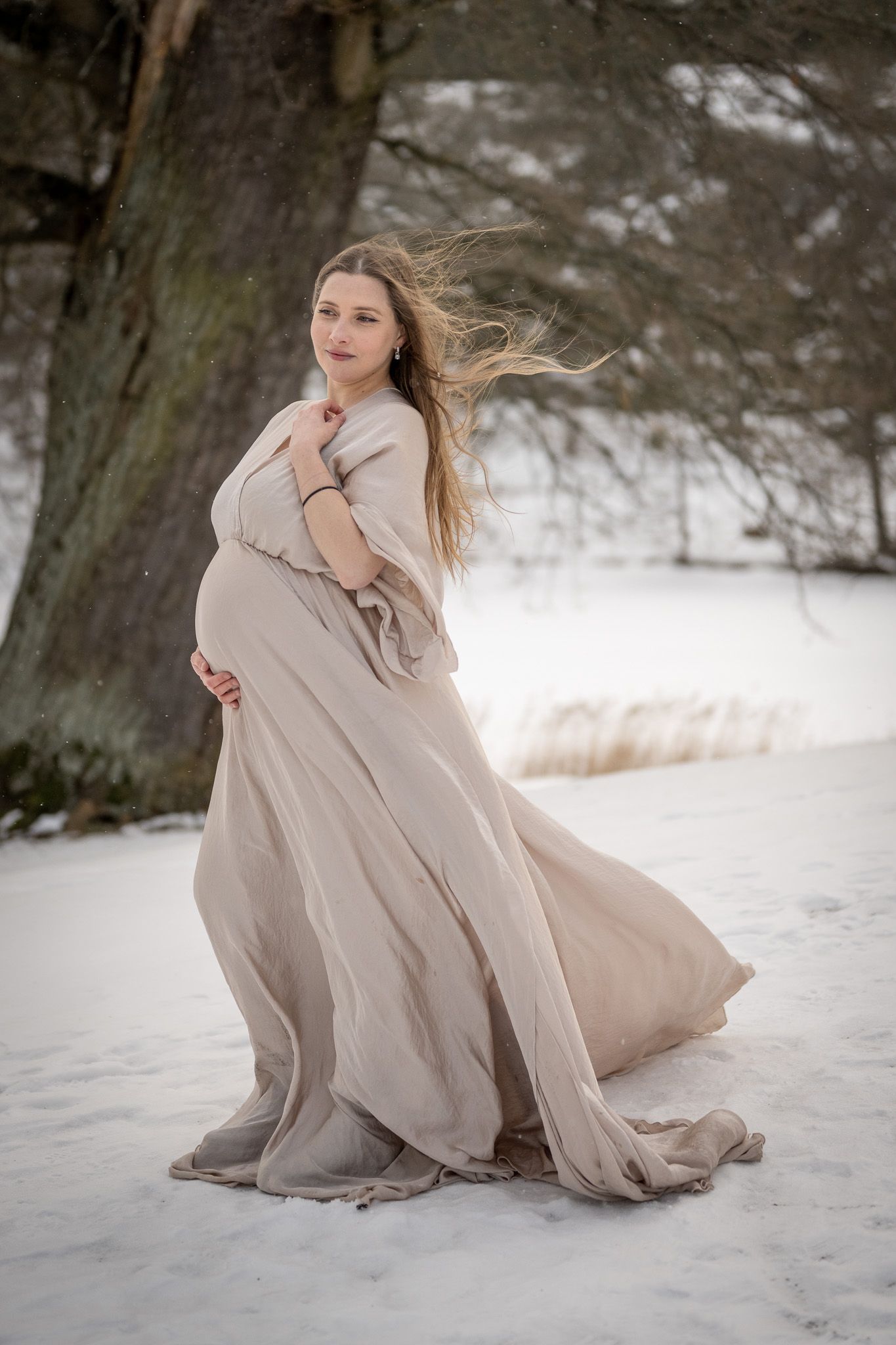 Behind the scenes när Fotograf Jessica Lindqvist fotograferar en kvinna som står i vattnet vid en brygga.