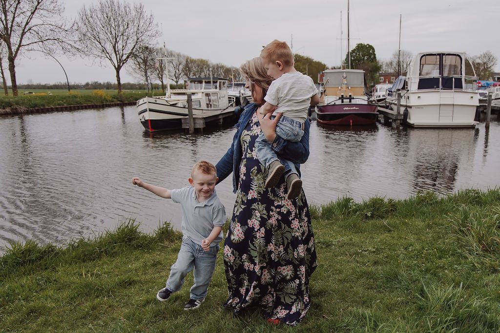 Natural family photo of grandmother hugging grandkids in Woerden park