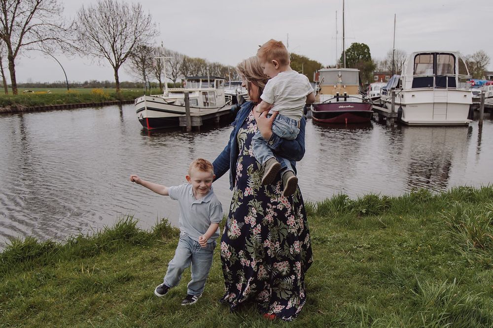 Natural family photo of grandmother hugging grandkids in Woerden park