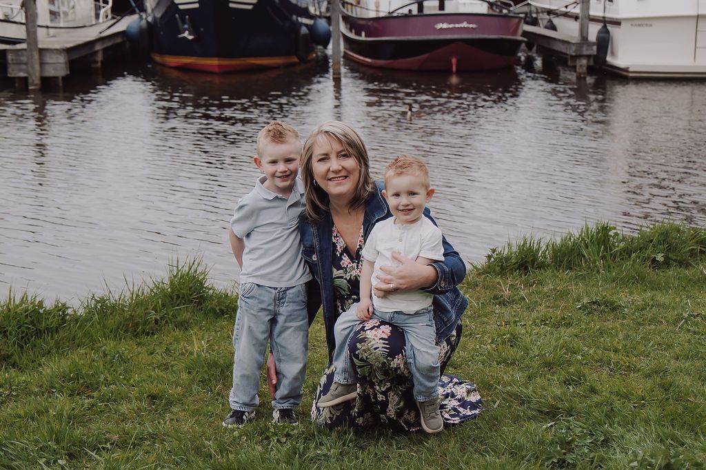 Grandmother smiling with grandchildren during candid family shoot in Woerden