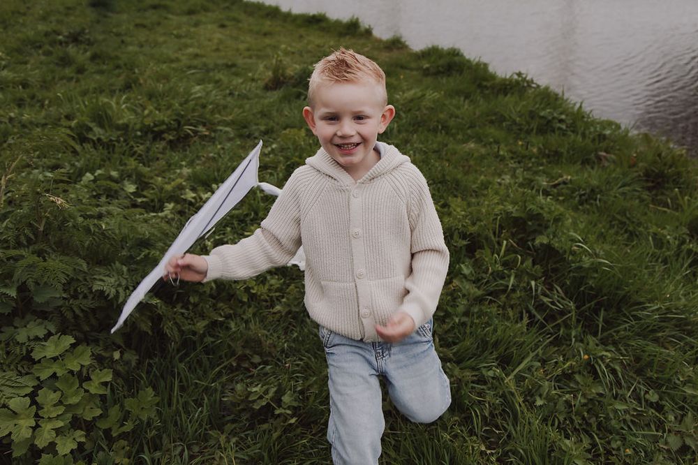 Kids playing with grandmother under kites during Woerden family photoshoot