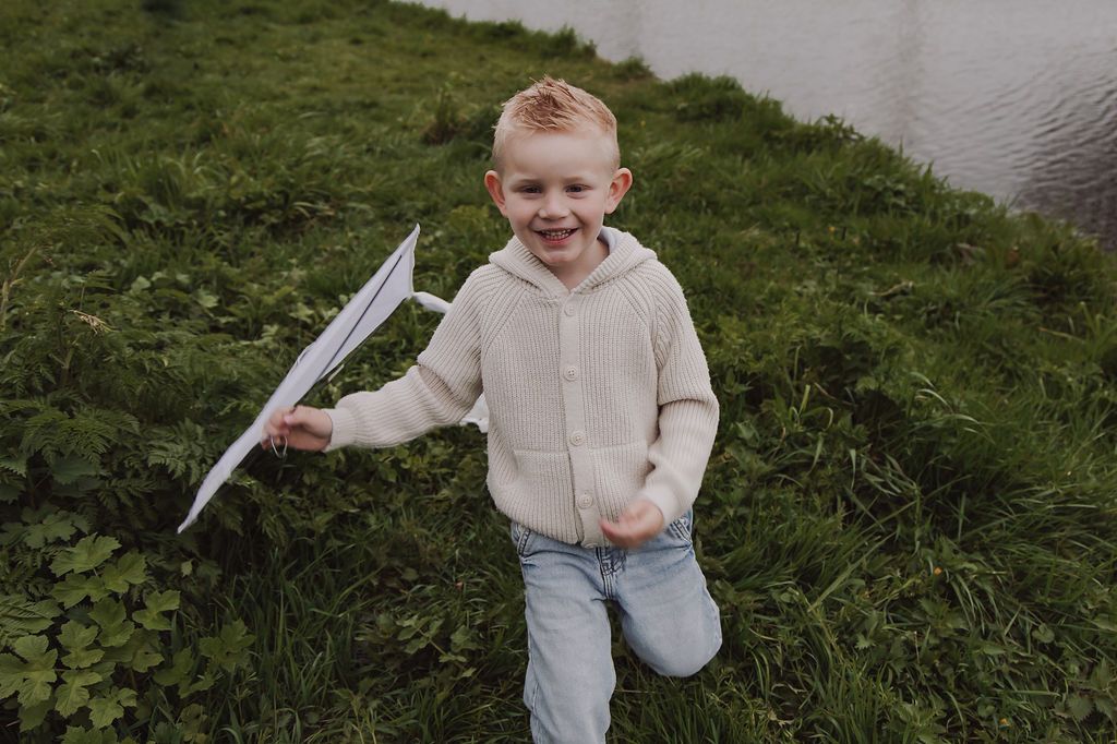 Kids playing with grandmother under kites during Woerden family photoshoot