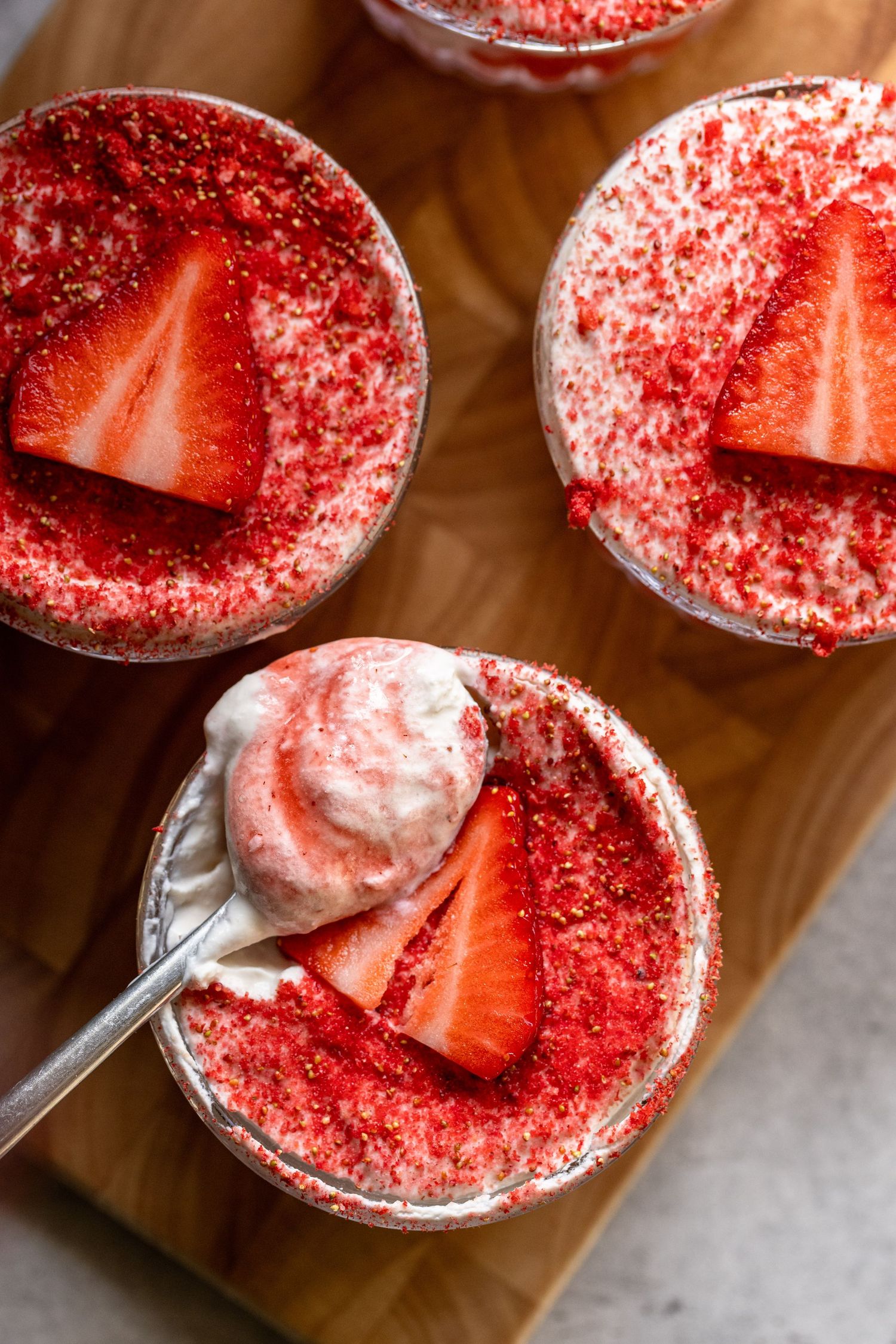 A spoon scoops creamy chocolate mousse from a glass bowl showing its smooth and airy texture.