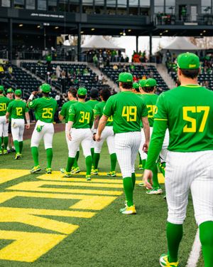 Oregon Ducks baseball team in green uniforms lined up on the field before a game at PK Park.