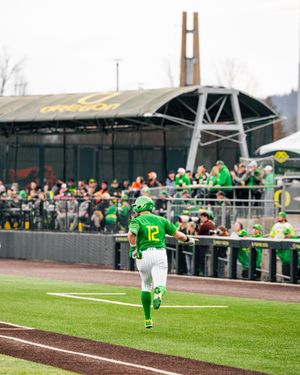 Oregon Ducks player #12 runs the bases at a college softball game at PK Park in Eugene, Oregon.
