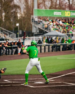 Oregon Ducks baseball player #7 batting at home plate during a Big Ten Championship game at a packed stadium.