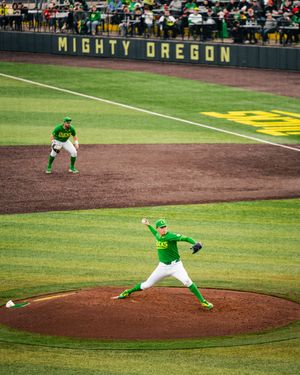 Oregon Ducks pitcher throwing on mound at Mighty Oregon baseball field during a college game.