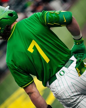 Oregon Ducks baseball player wearing green jersey number 7 and matching helmet during a college baseball game.