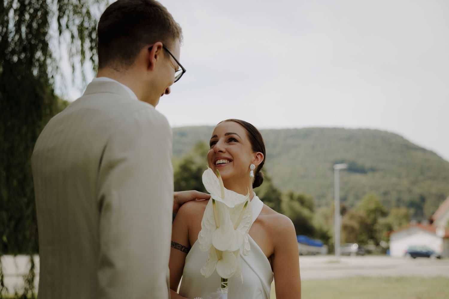 A couple shares a joyful moment during their wedding day outdoors.