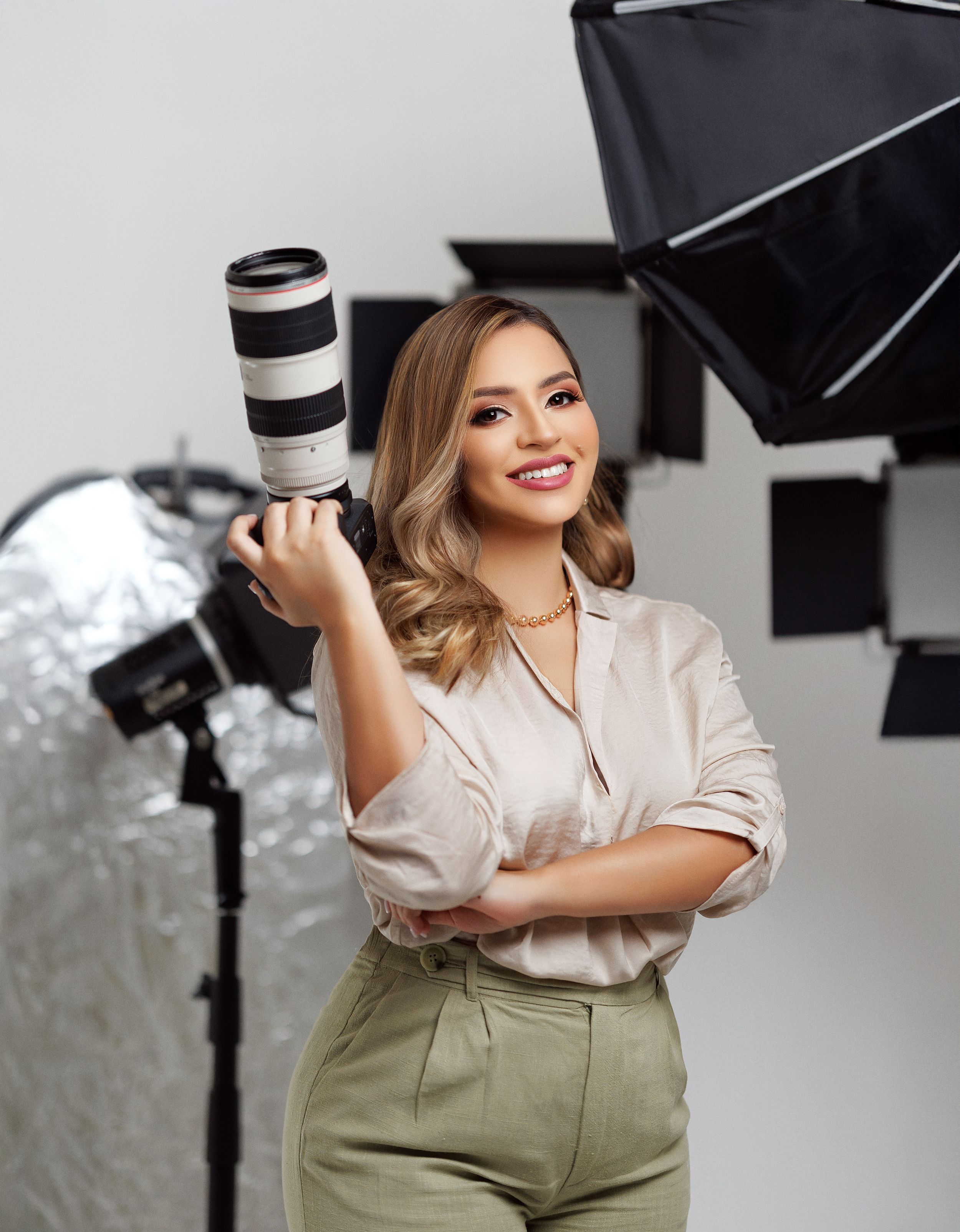 Professional branding photos of woman in business casual attire posing in photography studio.