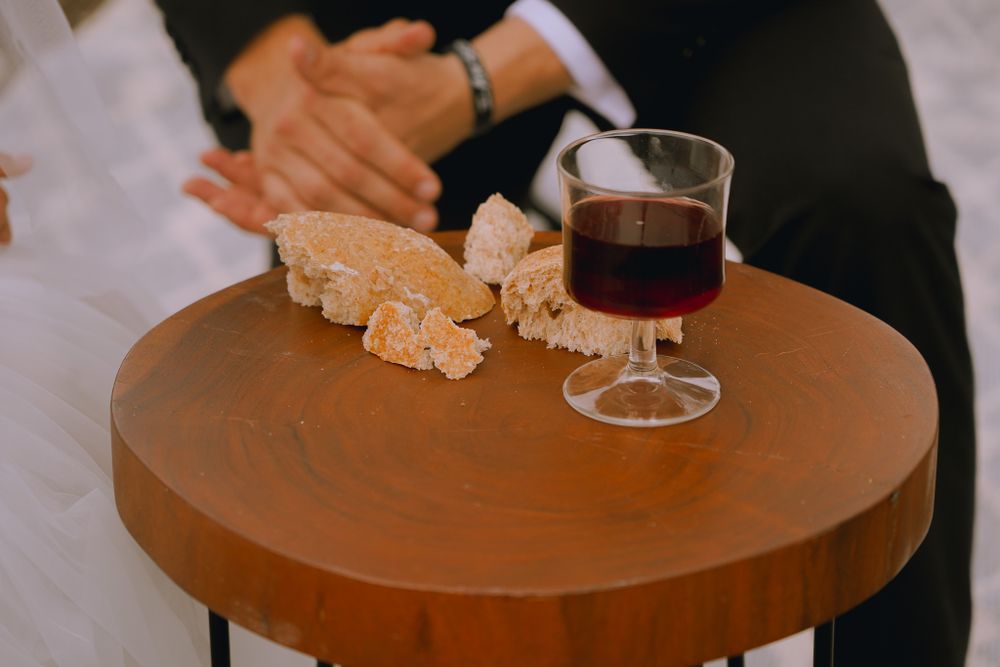 Still life of red wine and snacks on a wooden table at a wedding reception.
