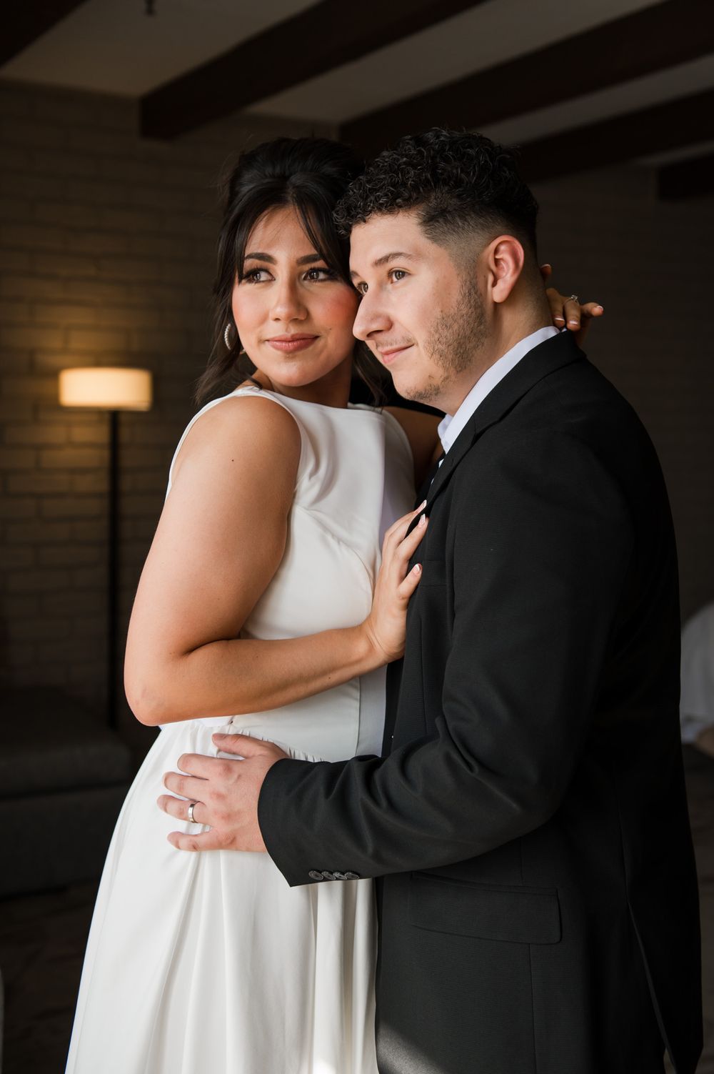 An intimate portrait of newlyweds sharing a tender moment in their wedding attire.