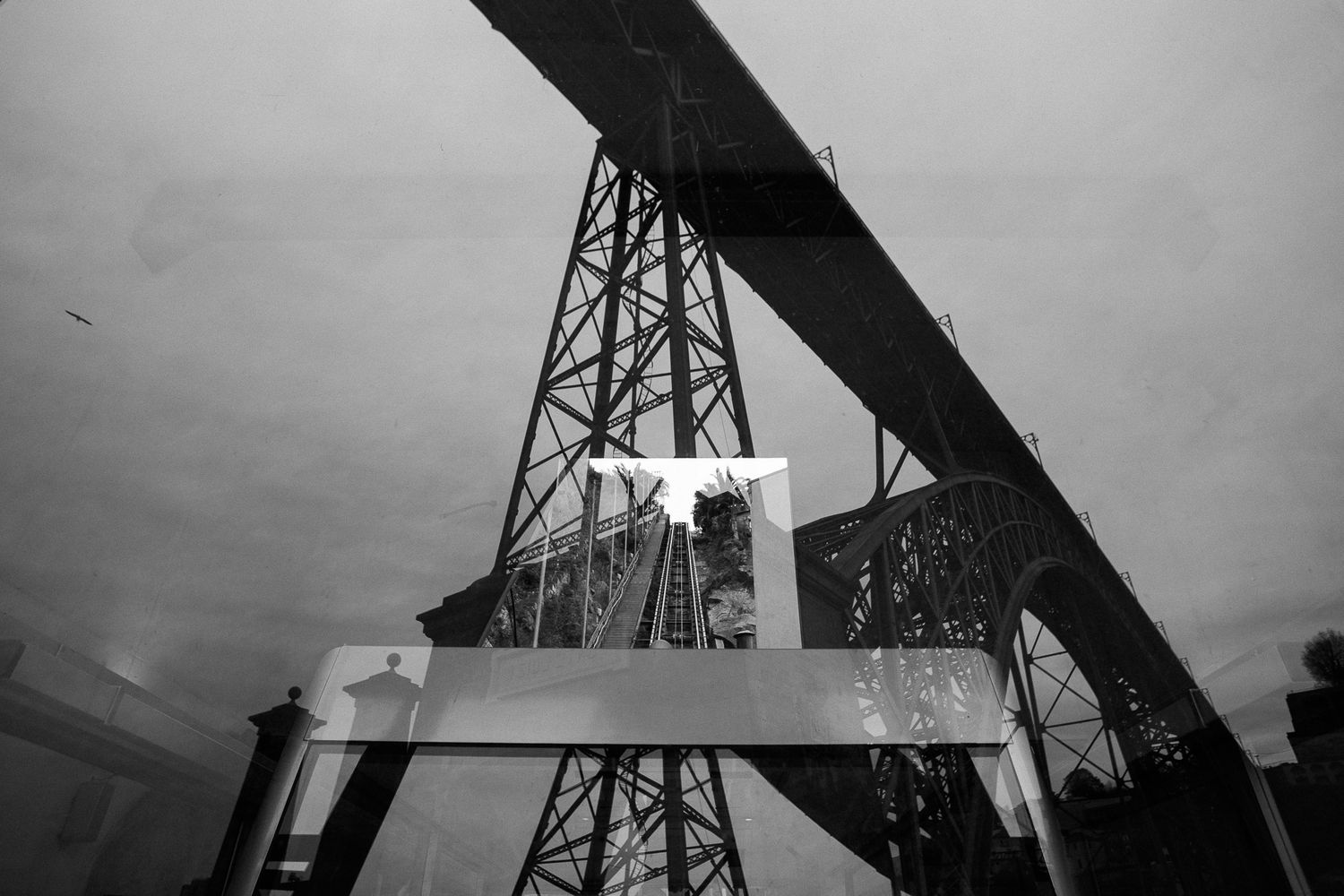 Industrial metal bridge structure photographed from below in dramatic black and white.