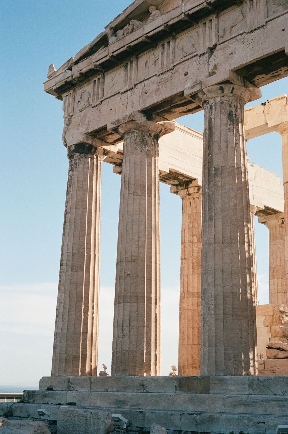 Ancient Greek Parthenon columns on the Acropolis in Athens, Greece, under a clear blue sky.