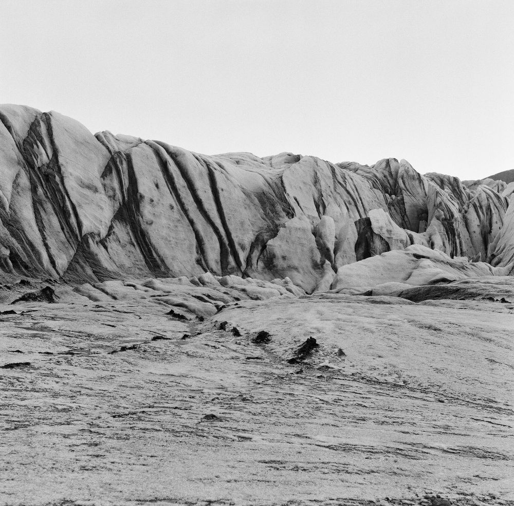 Dramatic black and white panoramic view of eroded rock formations stretching across a barren desert landscape.
