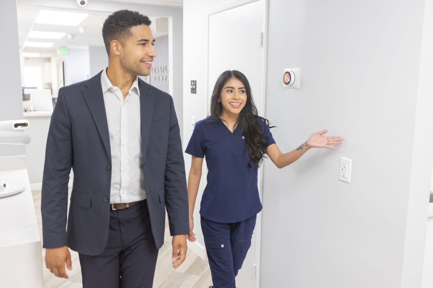 Professional healthcare workers walking and discussing in bright medical hallway.