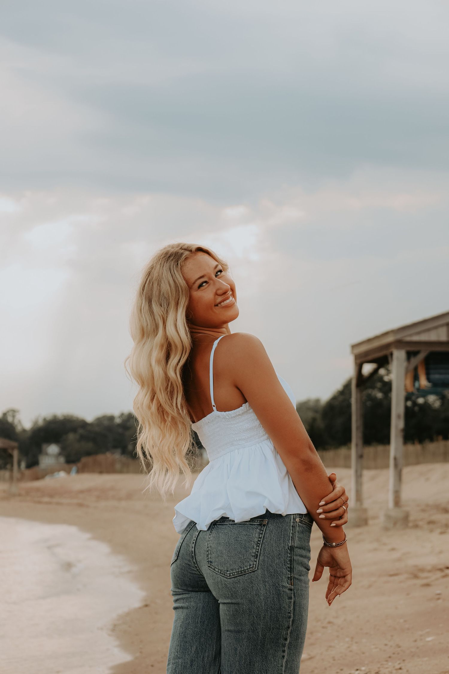 Candid moments captured on a beach wearing white top and jeans during sunset.