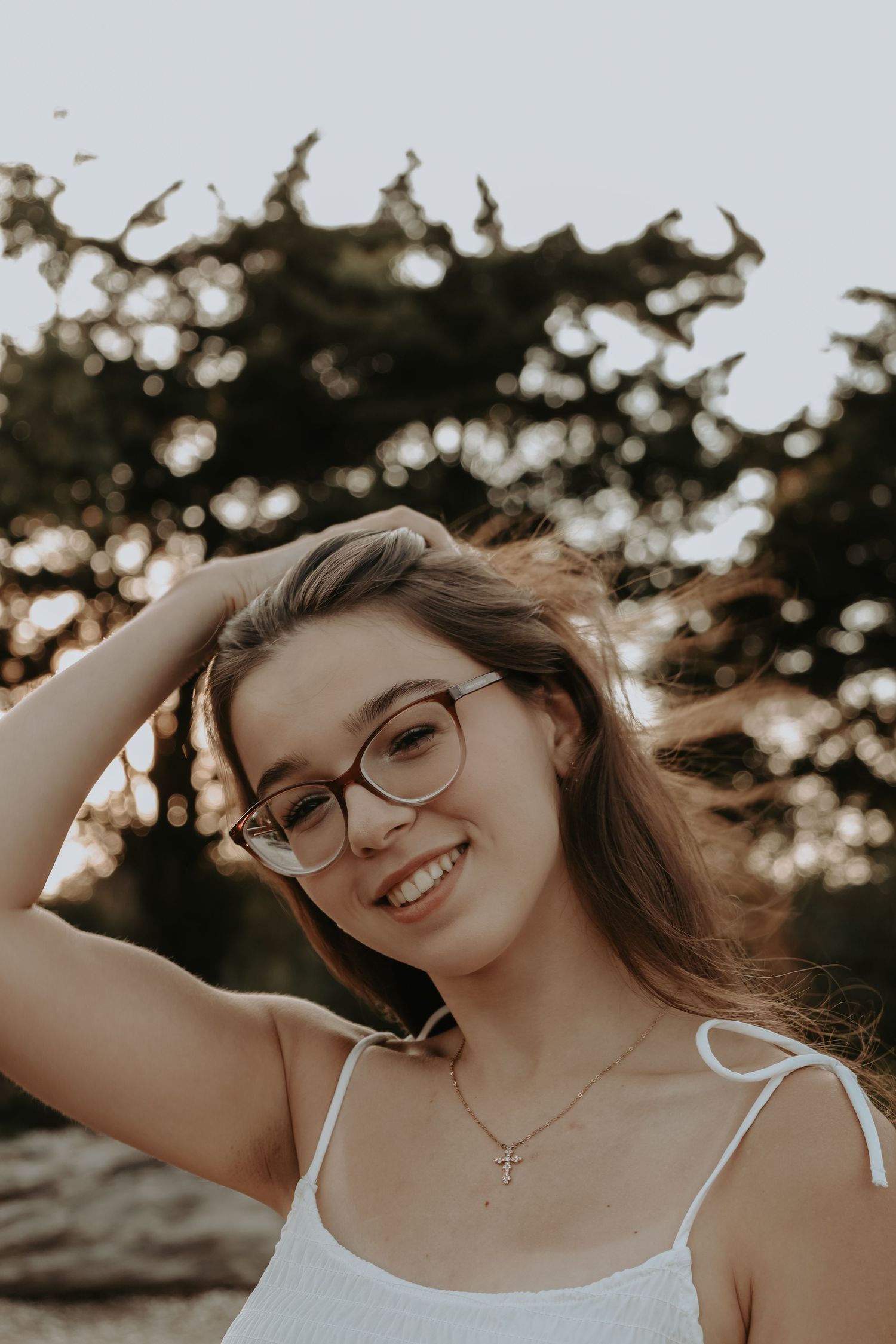 Candid portrait series of person with glasses in natural lighting at sunset showing joyful expressions and movement.