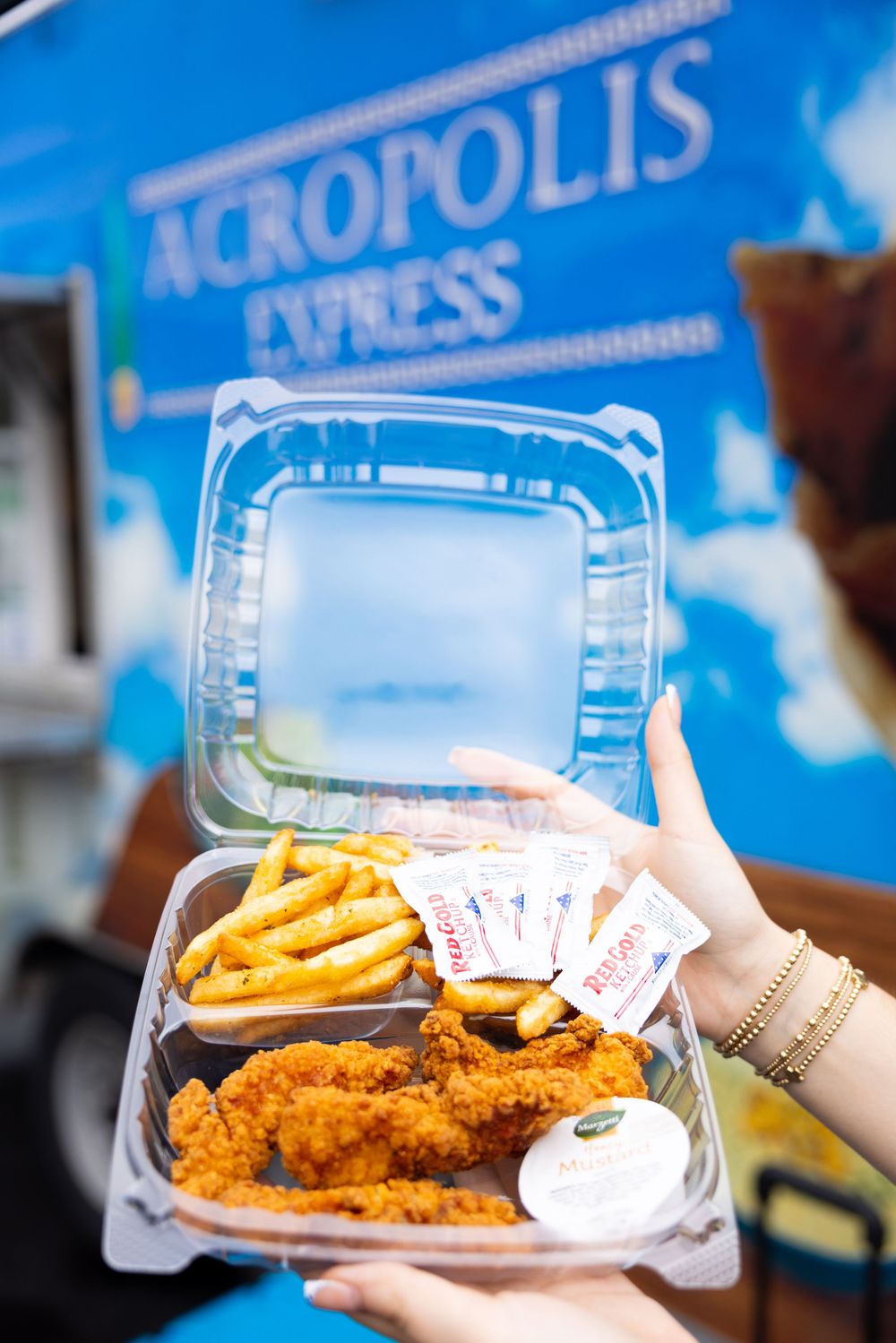 Branding session with series of takeout containers showing fried chicken and french fries against a blue backdrop.