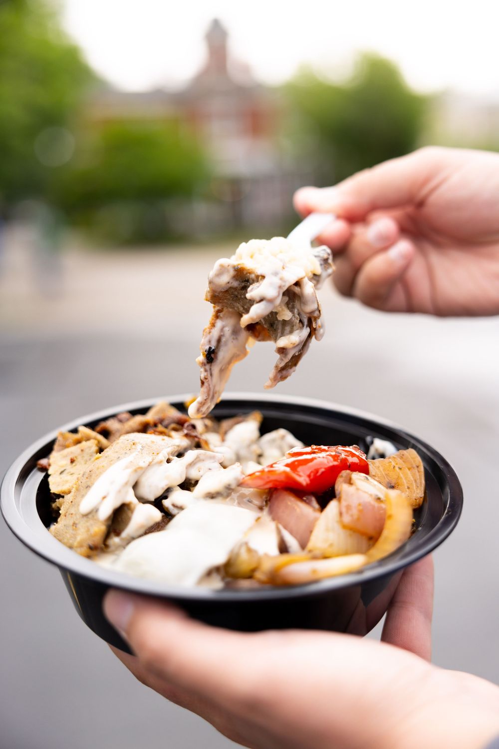Branding session with close-up shots of gourmet food servings in black containers being held.