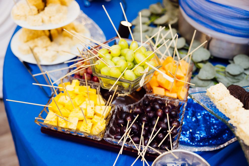 Branding session with appetizer display with cheese, fruits, and hors d'oeuvres on blue-themed banquet table.