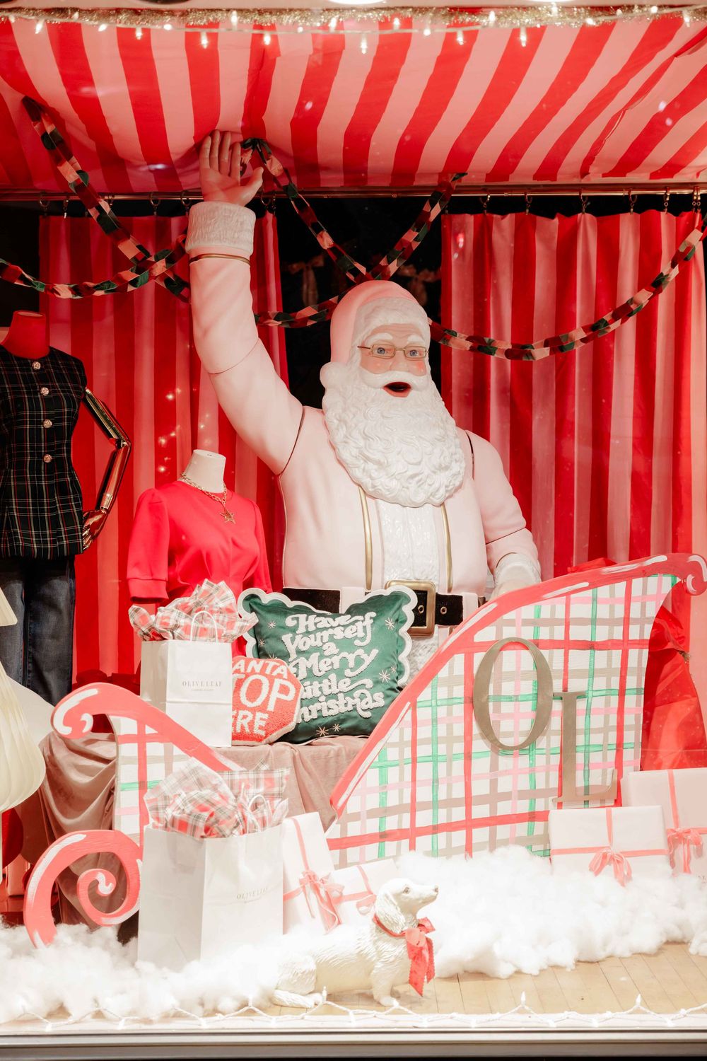 Branding session with red and white striped holiday display featuring Santa Claus figures and festive decorations.