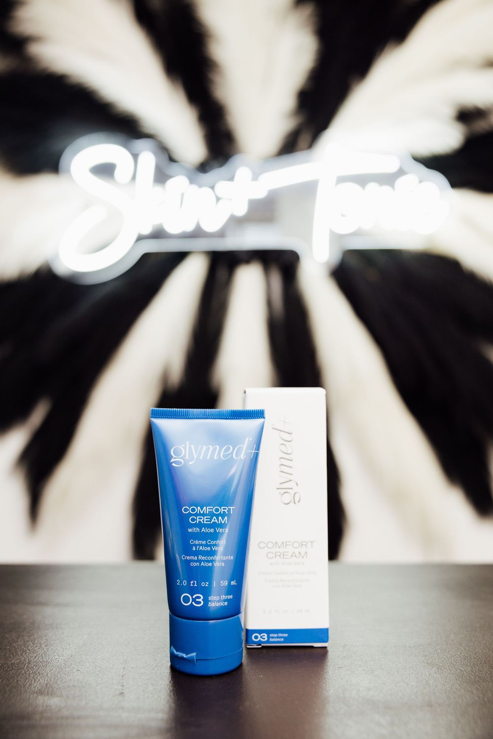 Branding session with blue skincare product containers displayed on a dark surface with white packaging.