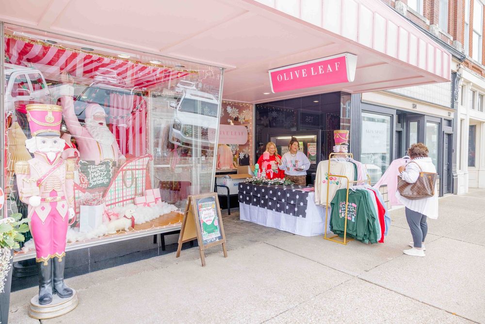 Branding session with pink and white decorated storefront with festive bunting and retail displays.