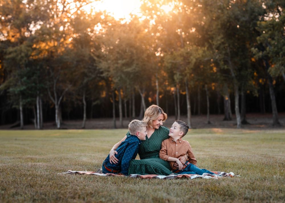A mom and her kids cuddling in a field with the golden light above in Crosby, Texas.
