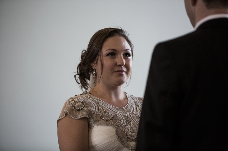 Close-up of bride in lace wedding dress during intimate moment at wedding ceremony.