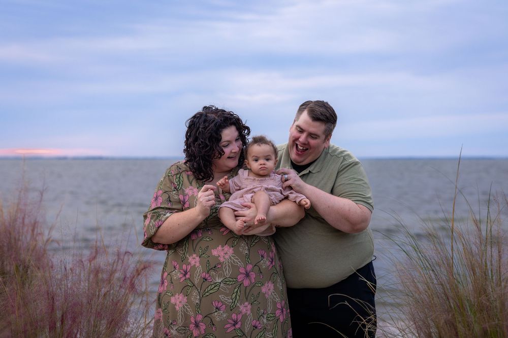A series of intimate family portraits captured against a scenic beach landscape during sunset.