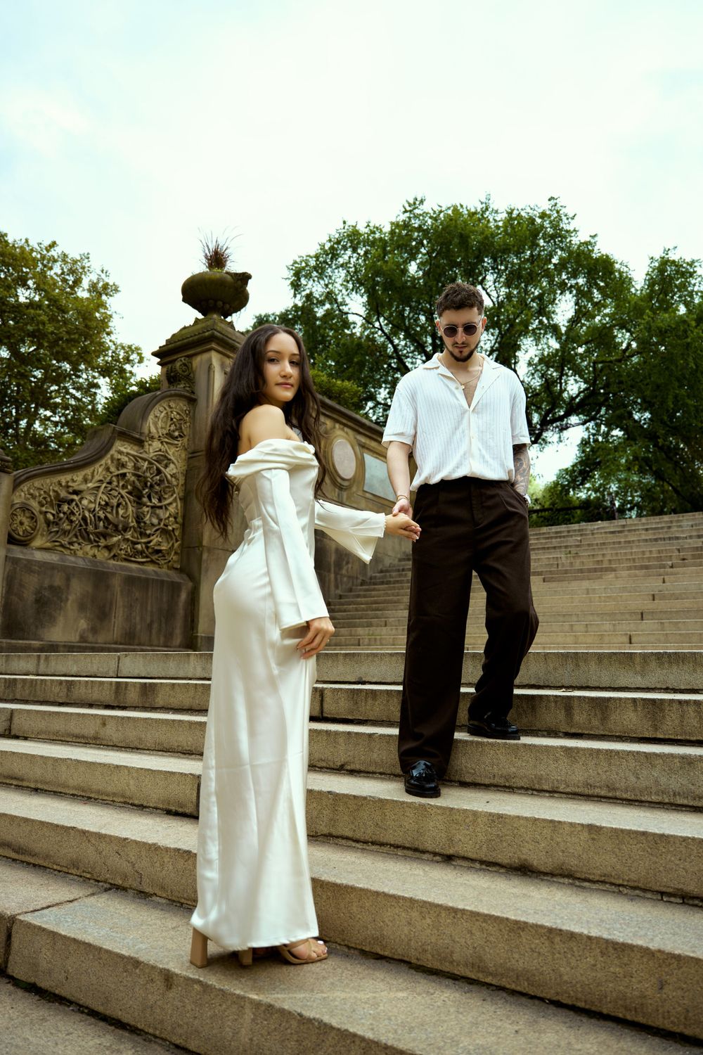 A couple shares a moment while sitting on stone steps at a historic location.