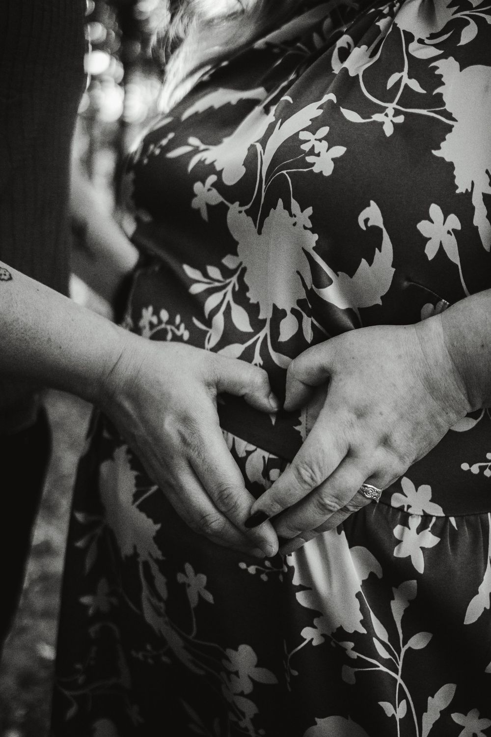 Close-up shots of hands against floral patterned fabric in black and white.