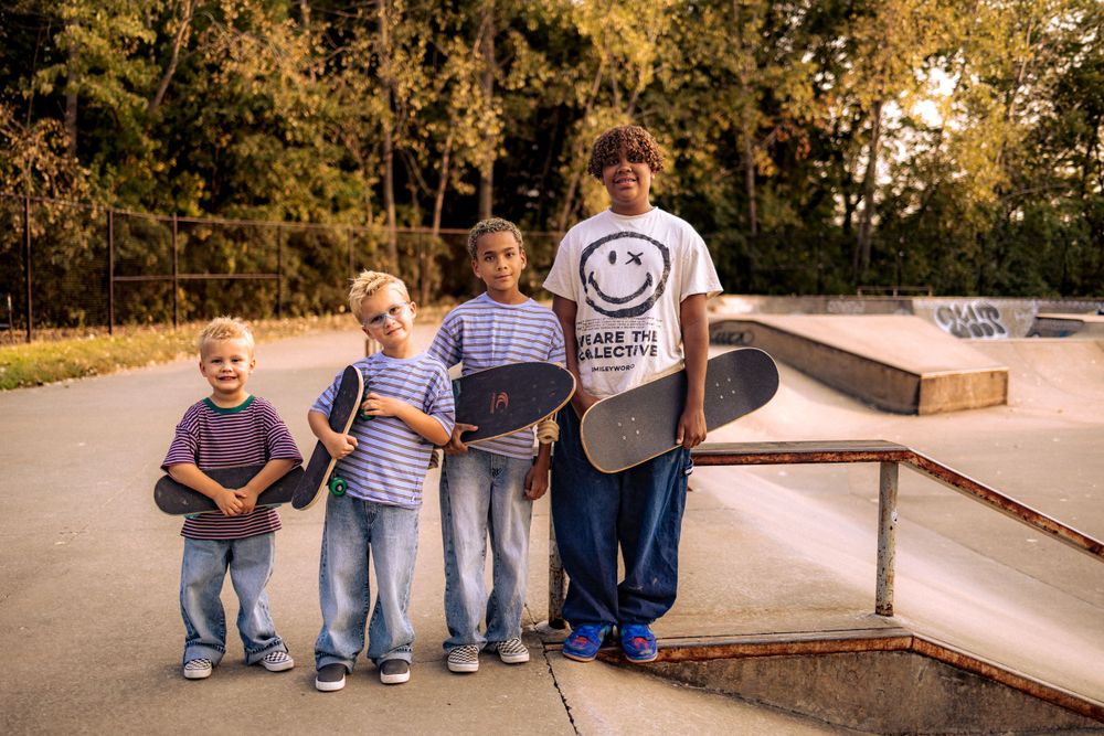 Group of people interacting at a skate park during a sunny day.