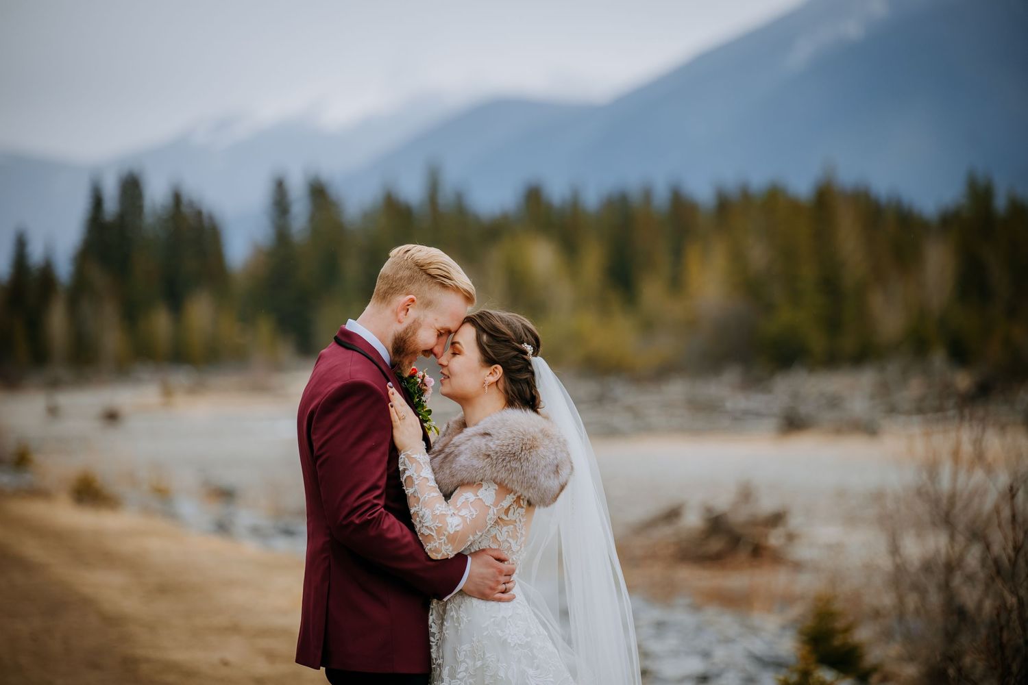 A tender wedding moment captured in autumn with golden foliage in the background.